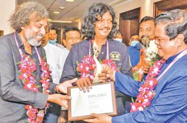 Media Minster Dr. Bandula Gunawardena  presents the award to the two Actors.