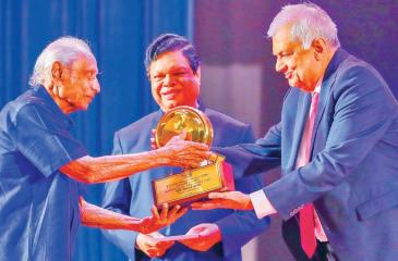 President Ranil Wickremesinghe presenting the award  to veteran actor Cyril Wickramage