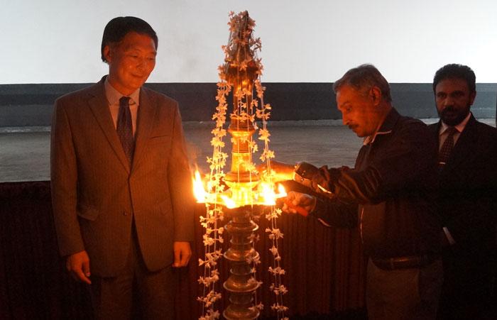 Secretary to the Ministry of Parliamentary and Reforms and Mass Media Nimal Bopage lights the oil lamp while the Ambassador looks on