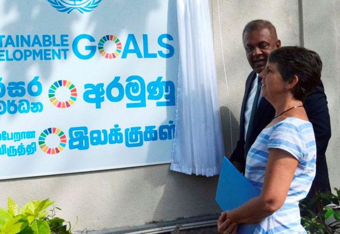 UN Resident Coordinator and UNDP Resident Representative, Una McCauley admires the slogan while Foreign Minister Mangala Samaraweera looks on