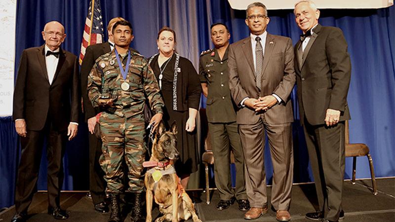 Brigadier Amith Senevirathna, mine detection dog Alvin, its handler Lance Corporal Nawarathne, and Ambassador Prasad Kariyawasam with Marshall Legacy Institute officials and guests.