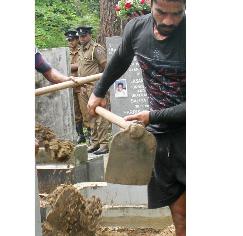 Slain Editor Lasantha Wickrematunga’s remains were reburied  yesterday morning following the conclusion of  the postmortem. The reburial took  place in the presence of the CID, Police officials, the Grama Sevaka Niladari of the  area and a family member. Pic: Ranga S. Udugama