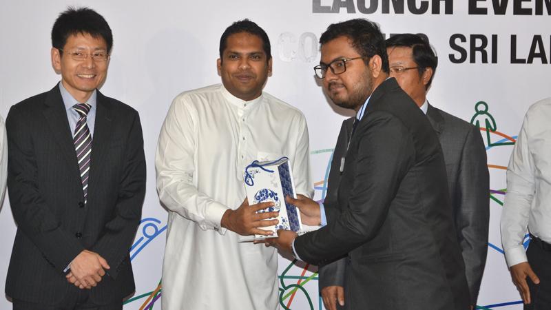 A student receives the sponsorship package from Minister of Telecommunication and Digital Infrastructure, Harin Fernando. Picture by VIPULA AMARASINGHE