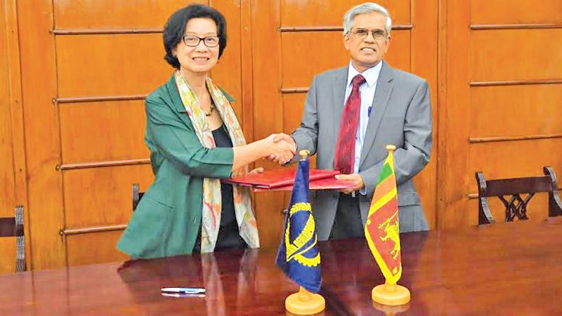 Secretary to the Ministry of Finance, Dr. R. H. S. Samarathunga and Country Director of ADB Sri Lanka Resident Mission, Sri Widowati exchange copies of the agreement.