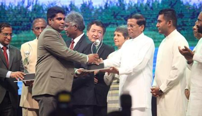 Manager, Deniyaya Estate, Madura Gamage receives the Merit Award from President Maithripala Sirisena