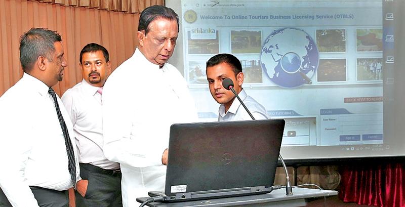Minister of Tourism Development, Christian Religious Affairs and Lands, John Amaratunga launches the OTBLS portal. DG, SLTDA, Malraj Kiriella and Director ICT, SLTDA, Udana Wickramasinghe were also present..