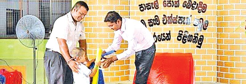 Expack officials present books and stationary to a schoolboy.