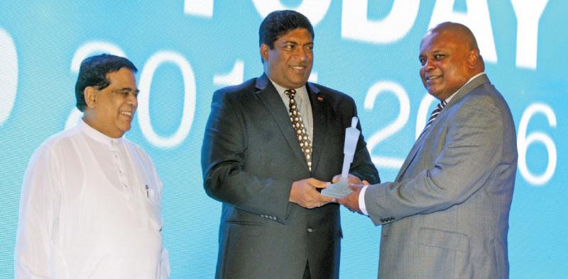 Mr. Ajith Gunawardena, Managing Director / Chief Executive Officer of Ceylinco Insurance PLC receiving the award from the Minister of Finance, Ravi Karunanayake as Minister of Transport and Civil Aviation Nimal Siripala De Silva looks on.