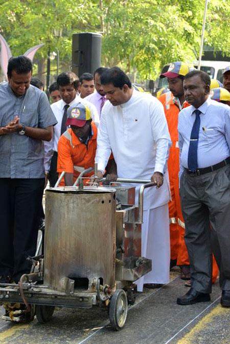  Minister of Media and Chief Government Whip Gayantha Karunathilake operates a road marking machine to change the colour of the Zebra Crossing white.