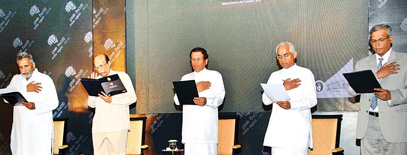 The National summit on anti-corruption took place yesterday. Here Elections Commissioner Mahinda Deshapriya, DEW Gunasekera, President Maithripala Sirisena, Deputy Minister Eran Wickremaratne and M.A. Sumanthiran MP take the pledge to fight corruption. (Pic: Ruwan de Silva)