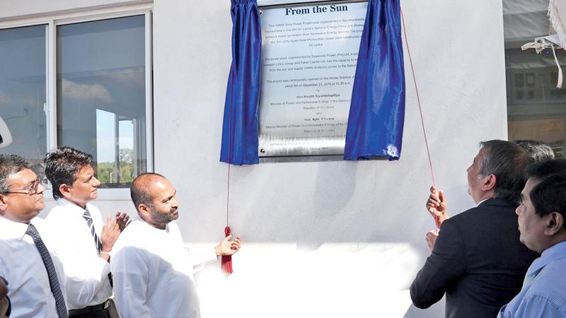 Power and Energy Minister Ranjith Siyambalapitiya unveils the plaque to mark the opening of the solar power plant in Hambantota.