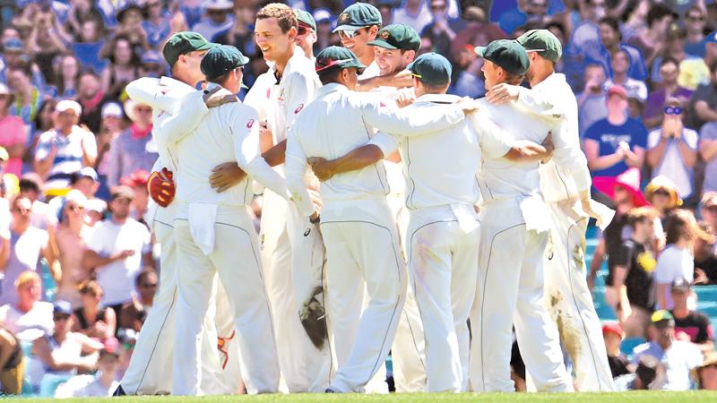Australia’s cricket team gather to celebrate after defeating Pakistan on the final day of the third cricket Test match. AFP
