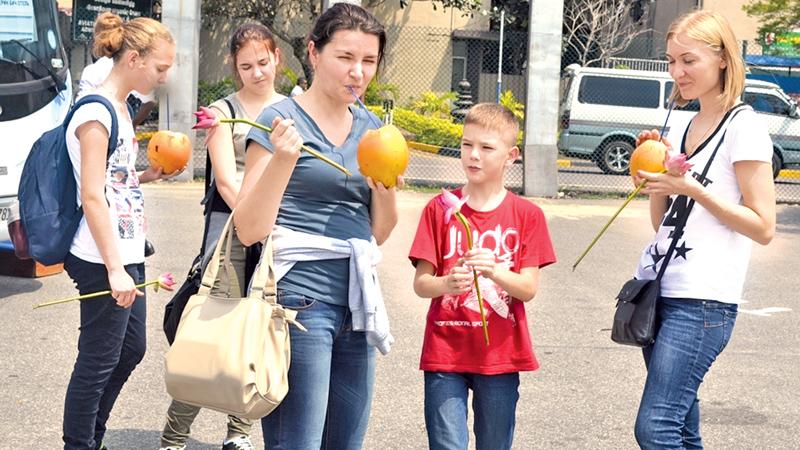 Tourists enjoy king coconuts on their arrival at BIA. Picture by Kumarasiri Prasad - File Photo