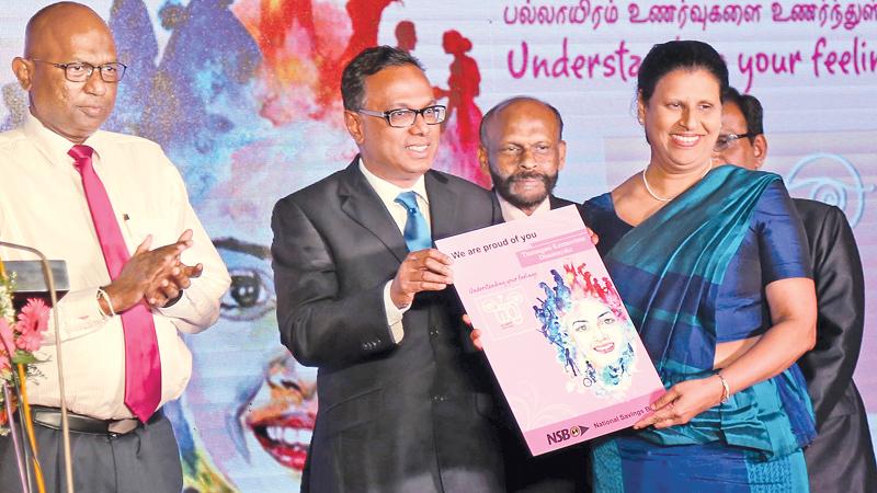 At the re-launch of NSB’s Sthree women’s savings account, eight women were presented first day accounts. Here first ever lady Public Trustee of Sri Lanka, Tharangani Keenawenna Dissanayake receives a replica of the account book from NSB Chairman Ashwin de Silva. NSB CEO/General Manager Dhammika Perera and officials look on .PICTURE BY VIPULA AMARASINGHE