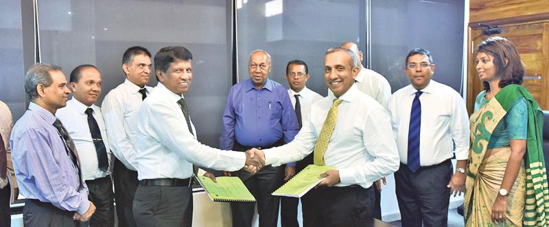 Chairman of RDA, Nihal Sooriyarachchi and Managing Director of MG Consultants Ranjith Gunaratne exchange copies of the agreement soon after signing the contract.