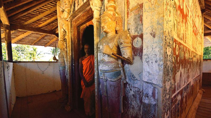 The Bhikku at the temple stands near the entrance to the image house (Budu Ge) on the upper floor. 