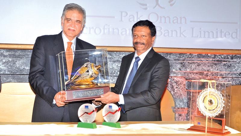 LOLC Group Managing Director and CEO Kapila Jayawardena presents a memento to Pak Oman Microfinance Bank Limited Chairman Yahiya Al-Jabri.
