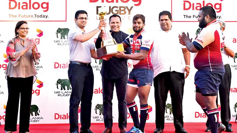 Kandy SC skipper, Roshan Weeraratne, receiving the Dialog Rugby League trophy from Sports Minister Dayasiri Jayasekera in the presence of Supun Weerasinghe, Group Chief Executive, Dialog Axiata PLC, Amali Nanayakkara, Group Chief Marketing Officer, Dialog Axiata PLC, Lasitha Gunaratne, vice president Sri Lanka Rugby and (partly hidden) Nihal Ratwatte, president,  Kandy SC.