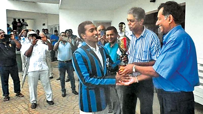 Team mates of the late Ranil Abeynaike who formed the spin triumvirate of 1973, Ajith Abeygunawardena and Ravi Abeywardena present the Ranil Abeynaike memorial trophy to Thomian skipper Romesh Nallaperuma. Pic by Priyan de Silva