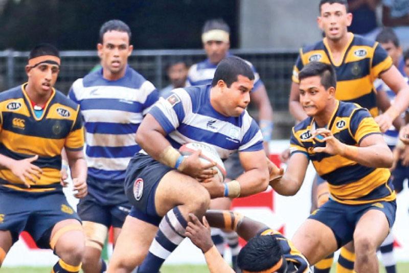 St. Joseph’s College prop forward Shavon Gregory (ball in hand) barging through Royal hooker Hamza Barrie who is on the ground trying valiantly to stop him in the Singer ‘A’ division inter-school league rugby match played at the Royal Sports Complex yesterday. (Pic by Chintaka Kumarasinghe)    
