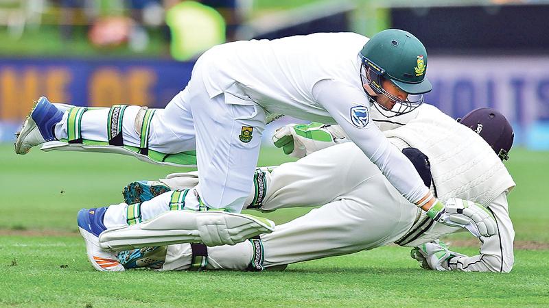 South Africa’s Dean Elgar (front) runs into New Zealand wicket-keeper BJ Watling during day  four of the first Test played at Wellington on Saturday. AFP    