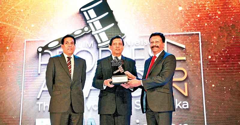 Group Managing Director/CEO of the LOLC Group, Kapila Jayawardena (right) receives the award from Director, Marketing, Singer (Sri Lanka), Kumar Samarasinghe, the main sponsor of the event. Chief Officer, Marketing Communications, LOLC Group, Susaan Bandara looks on.   