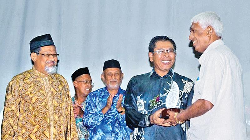 Edward Chandrasiri receives a memento from chief guest