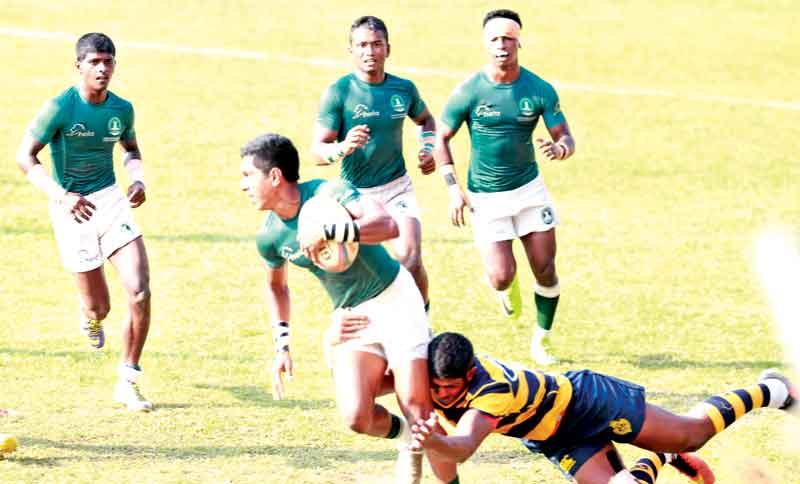Isipathana vice captain cum full back Chamod Frrnando (ball in hand)  trying to evade a tackle from Royal captain and fly half Ovin Askey.  Also in the picture is Isipathana scrum half Harith Bandara (externally  left of Chamod 