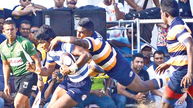 A Josephian player (ball in hand) is tackled by Peterite fly half Steffen Sivaraj in their schools rugby match played at Bambalapitiya yesterday. Pic by Saman Mendis