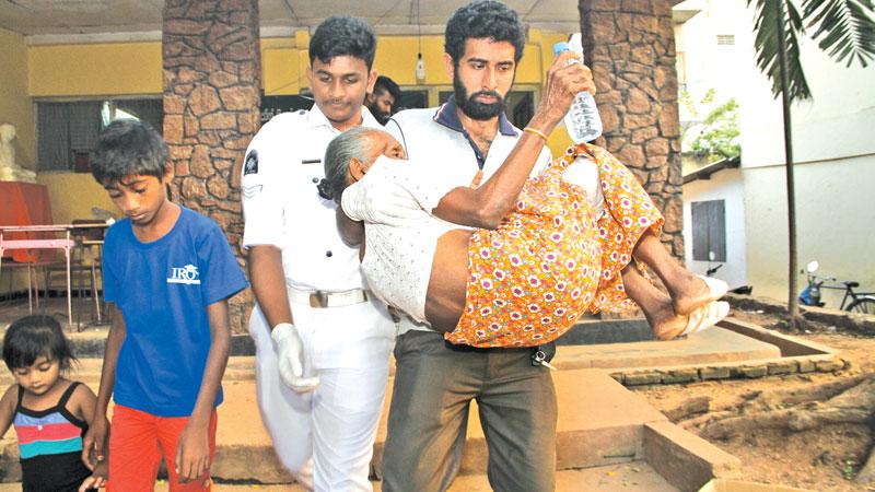 An 86-year-old woman who was displaced due to the catastrophe at Meetotamulla being taken back to camp after medical treatment. PIC: SULOCHANA GAMAGE