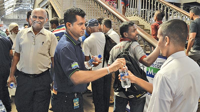 Mobitel staff distribute bottles of water