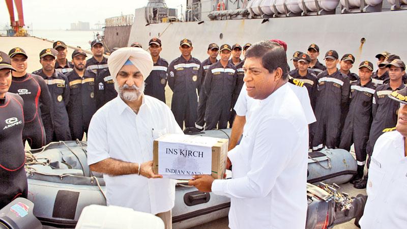 Indian High Commissioner Taranjit Singh Sandhu makes a token presentation of the relief goods to Foreign Minister Ravi Karunanayake.