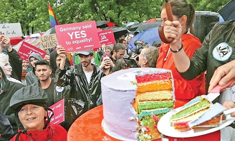 Supporters of gay rights gathered outside the Chancellery cut a cake to celebrate a vote at the nearby Bundestag in which parliamentarians approved a new law legalizing gay marriage in Germany on June 30, 2017 in Berlin, Germany. In a historic vote following emotional statements by parliamentarians both for and against the issue Germany is transferring homosexual relationships from a privileged partnership to marriage with the same rights as marriage between heterosexual couples. (Getty Images)    