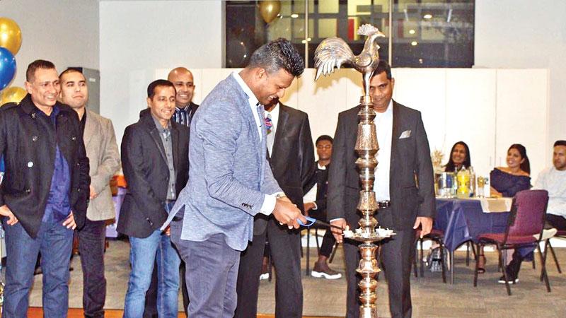 President of the SACOBA, Melbourne Manjula Munasinghe lights the traditional oil   lamp while the members of the Association look on.     