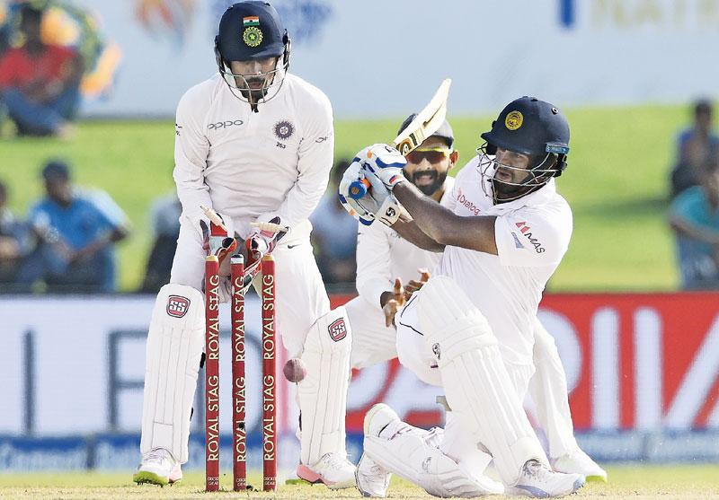 Dimuth Karunaratne who top scored for Sri Lanka with 97 in the second innings is bowled by Ravichand Ashwin on the fourth day of the first cricket Test at the Galle International Stadium yesterday. (Pic by Saman Mendis)