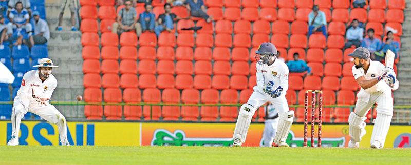 Indian captain Virat Kohli is caught by Sri Lanka slip fielder Dimuth Karunaratne off Lakshan Sandakan (not in picture) for 42 on the opening day of the third and final cricket Test at the Pallakele International Stadium yesterday.  (Pix by RUKMAL GAMAGE)   