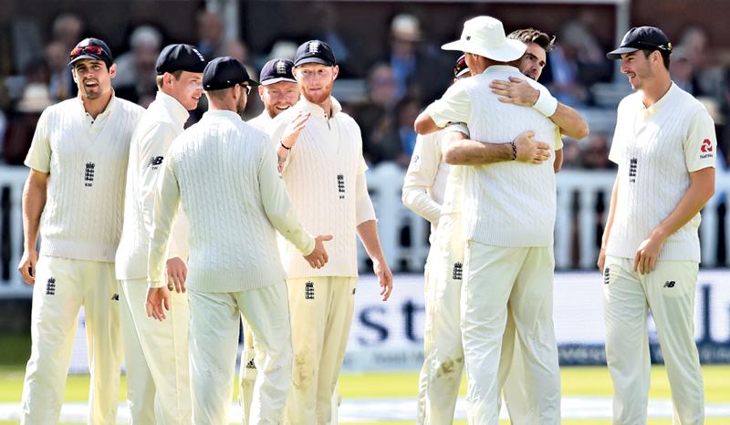 England’s James Anderson (2R) celebrates with teammates after taking the wicket of West Indies’ Shai Hope during the third day of the third international Test match between England and West Indies at Lord’s cricket ground in London. - AFP