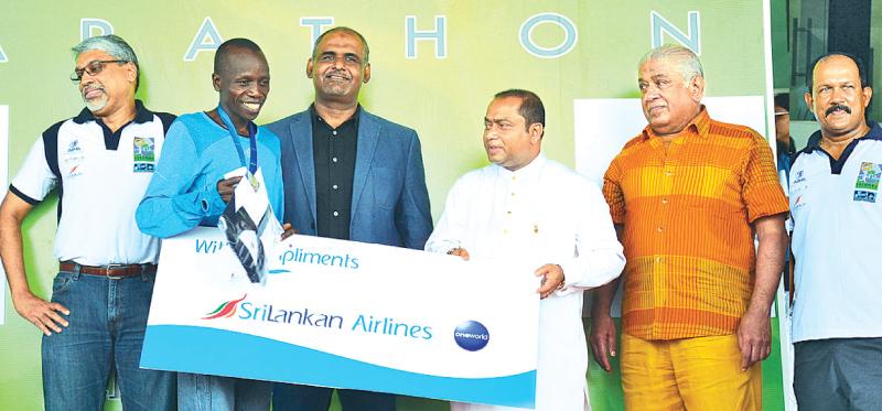 Full Marathon winner James Tallam receives the award fromWestern Province Chief Minster  Isuru Devapriya. Also in the picture are from left chief Executive Offcer SriLankan Airlines, Suren Ratwatte, Acting Sports Minister M.H.M. Haris, Chairman Tourist Promotion Board Udaya  Nanayakkara and Chief organizer LSR Colombo Marathon and Chairman Sports  Rieson Lanka Ltd. Thilak Weerasinghe  