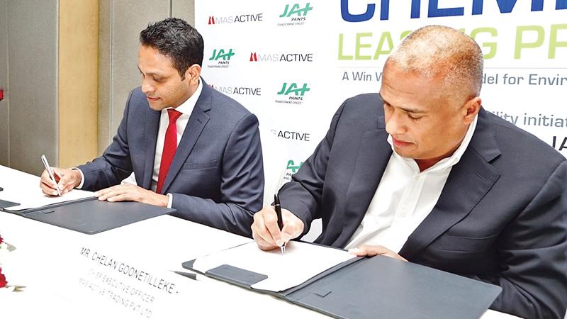Managing Director of JAT Holdings Aelian Gunawardene (in red tie) and MAS Active CEO Chelan Goonetilleke sign the agreement.