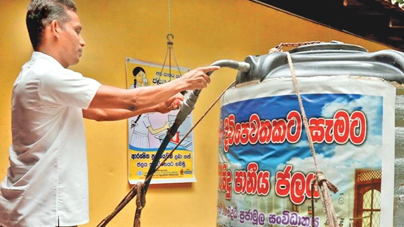 Warnasooriya  with a purified water tank