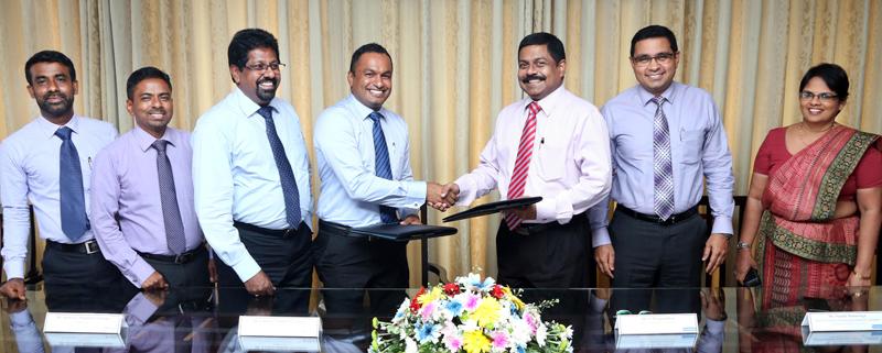 Commercial Bank’s Executive Director/Chief Operating Officer S. Renganathan (third from right) and Hayleys Agriculture Director Lushan Nalinda Abeysekara exchange the agreement. Senior representatives of the two companies look on.    