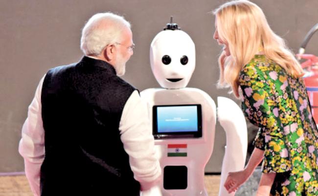 Indian Prime Minister Narendra Modi and Ivanka Trump greet Mitra, the made in India robot.