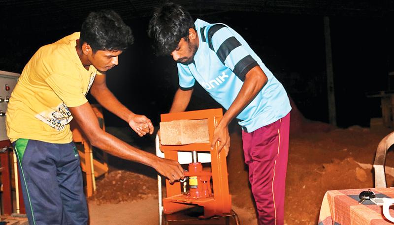 Two young men  demonstrate the strength of  the brick.