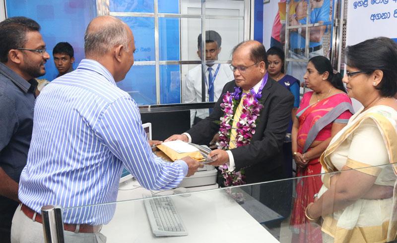Commercial Bank Chairman Dharma Dheerasinghe (third from right) accepts the first deposit from a customer at the opening of the Bank’s Rambukkana branch.  