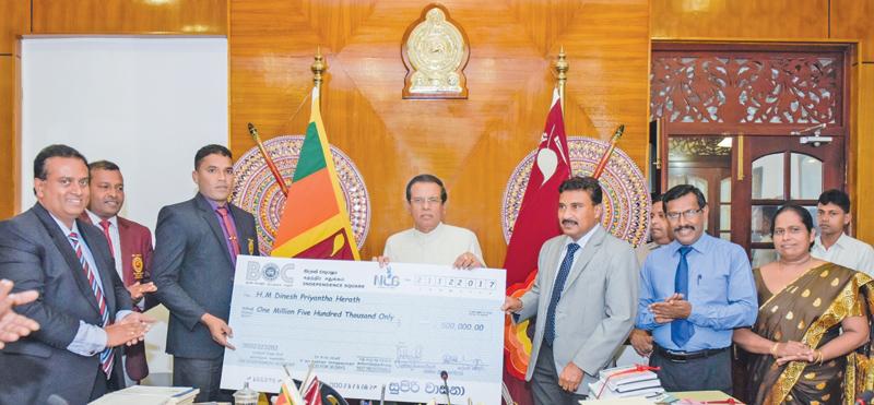 President Maithripala Sirisena handing over the cheque to Dinesh Priyantha.     