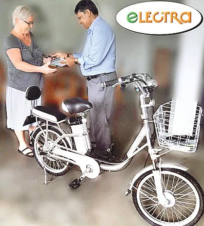 Managing Director, Eco Trans Lanka Holdings, Chrysantha Fernando presents  the keys to a customer who purchased an electric motorcycle.