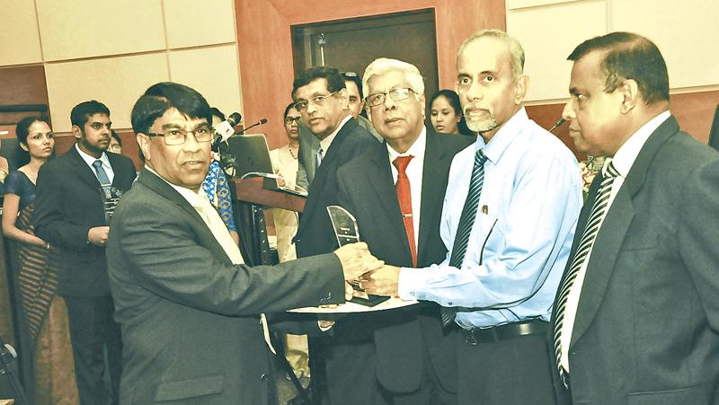 Senior Research Consultant Dr. Sumith Abeysiriwardena  receives the award from Chairman, SLCARP, Dr. Gerry Jayawardena. State  Secretary, Ministry of Agriculture, Bandulasena and Secretory, Ministry  of Agriculture, B. Wijayaratne look on.  