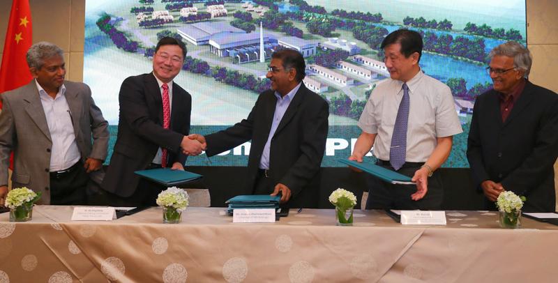 Sri Lankan and Chinese officials exchange documents following the signing of the agreement at an event held to announce the commissioning of the dendro power plant in September.