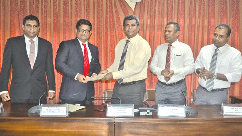 Airtel and Kelaniya University officials exchange the agreement.