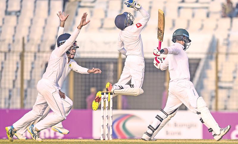 Sri Lanka wicket-keeper Niroshan Dickwella celebrates with his team mates the dismissal of Bangladesh opener Tamim Iqbal on the fourth day of the first cricket Test at the Zahur Ahmed Chowdhury Stadium in Chittagong on Saturday. AFP    